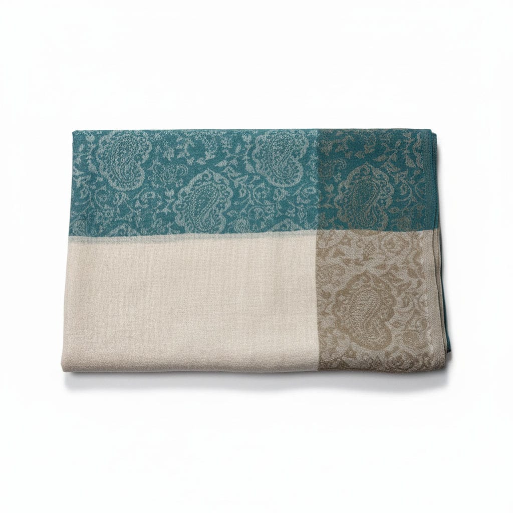 Folded fabric with paisley pattern in teal, beige, and gray on a white background